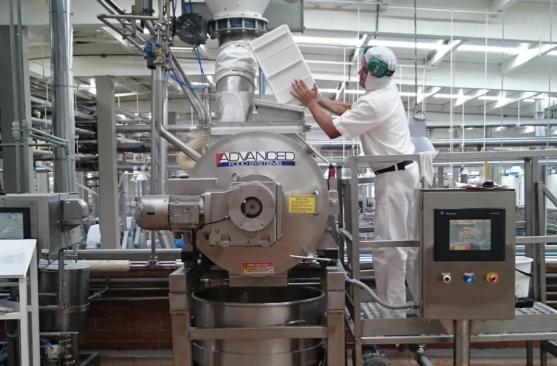 Worker pouring mix into an industrial mixer